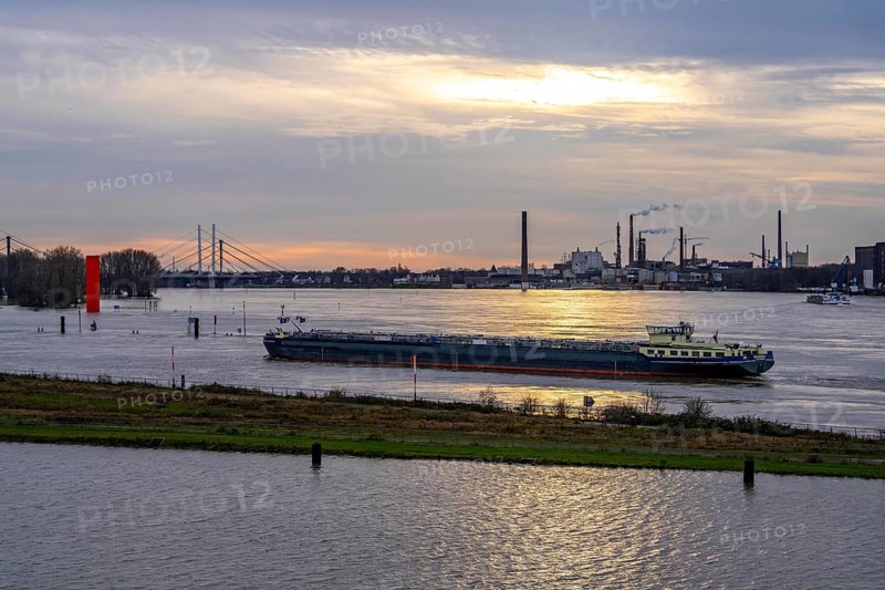 High water on the Rhine near Duisburg, freighter enters the harbour canal, Neuenkamp Rhine bridge, old and new construction, landmark Rhine orange, washed over by high water, North Rhine-Westphalia, Germany, Europe