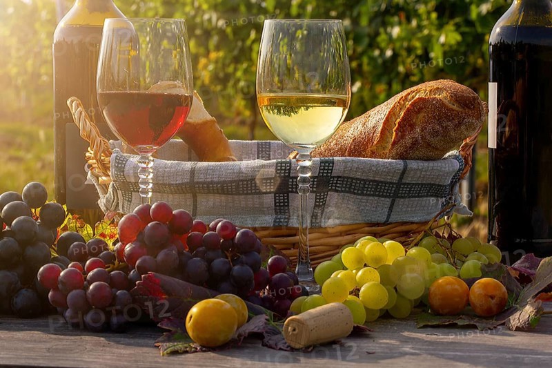 Symbolic image: Ripe grapes decorated with wine glasses on a wooden table