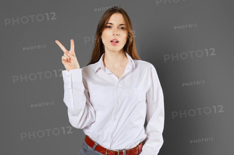 Young woman shows two fingers or victory sign. Counting with fingers concept