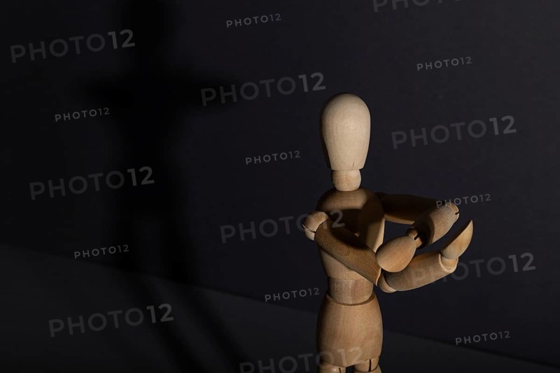 Wooden mannequin shows obscene gesture fuck off with hands on gray background. protest, riot, agression, contempt concept. copy space, hard light