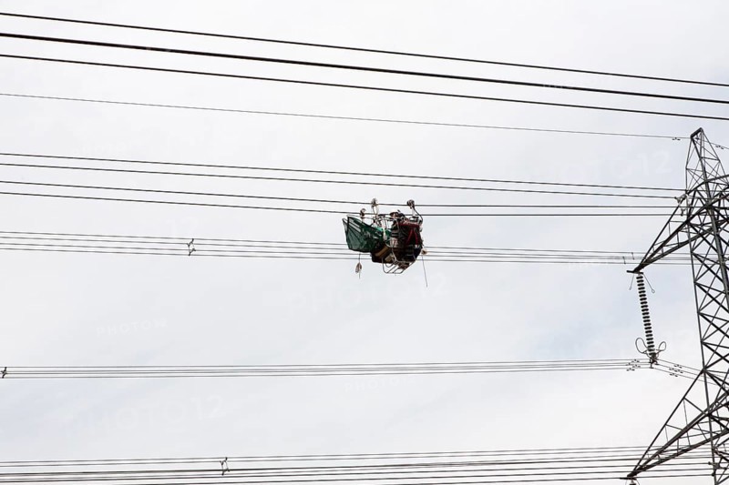 Maintenance work being done on high voltage electricity cables from Sizewell nuclear power station viewed from below looking up, Suffolk, England, UK