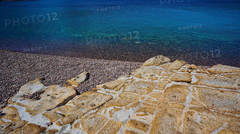 Rocky coast with pebbles and clear blue water under a blue sky, Lambi beach, pebble beach, Patmos, Dodecanese, Greek islands, Greece, Europe
