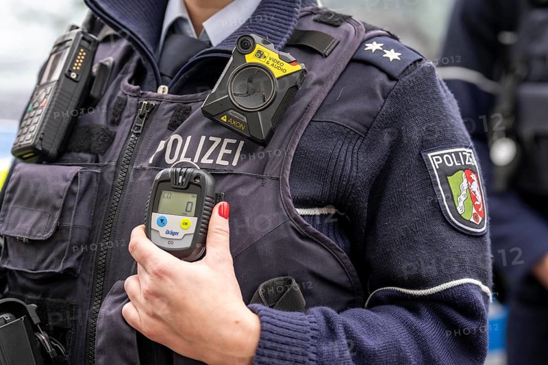 Police, policewoman with equipment waistcoat, CO measuring device device, measures the carbon monoxide content in the air during operations, e.g. in flats, the gas is odourless and has a lethal effect, above a bodycam, North Rhine-Westphalia, Germany, Europe