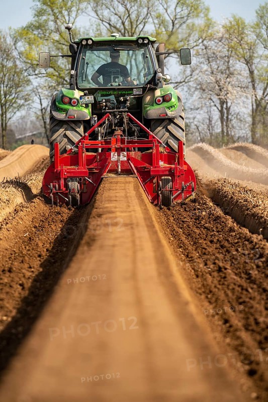 A farmer builds asparagus ridges on a field with the help of an asparagus tiller, in which the asparagus then grows, Dormagen, North Rhine-Westphalia, Germany, Europe
