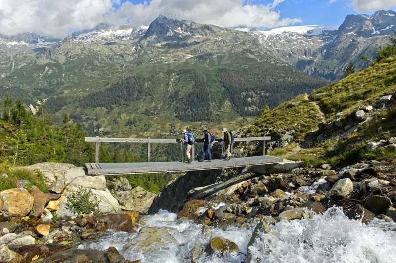 Hikers cross a narrow bridge over the Nästbach torrent on the way to the Bietschhorn hut, near Blatten, Lötschental, Valais, Switzerland, Europe