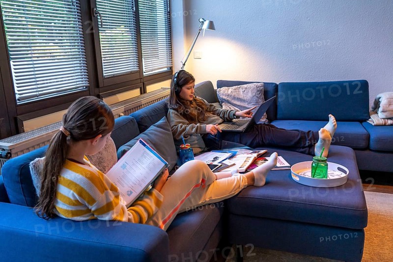 Homeschooling, 2 girls, sisters, 11 years old, learning at home, home learning, lessons at home, distance learning, chat with teachers and classmates via laptop, tablet PC, symbolic image
