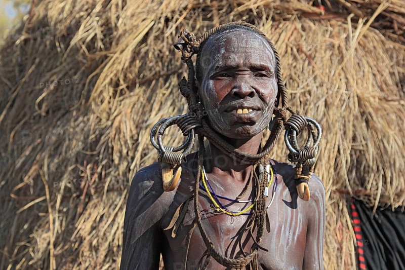 South Ethiopia, in the Maco National Park, Mursi tribe, older Mursi woman with naked upper body and painted skin and earrings, Ethiopia, Africa