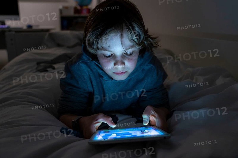 A boy plays computer games on a tablet PC