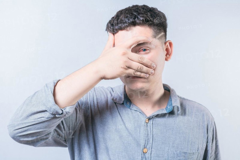 Young person with irritated eyes. People with conjunctivitis covering eye isolated. Man with eye infection isolated