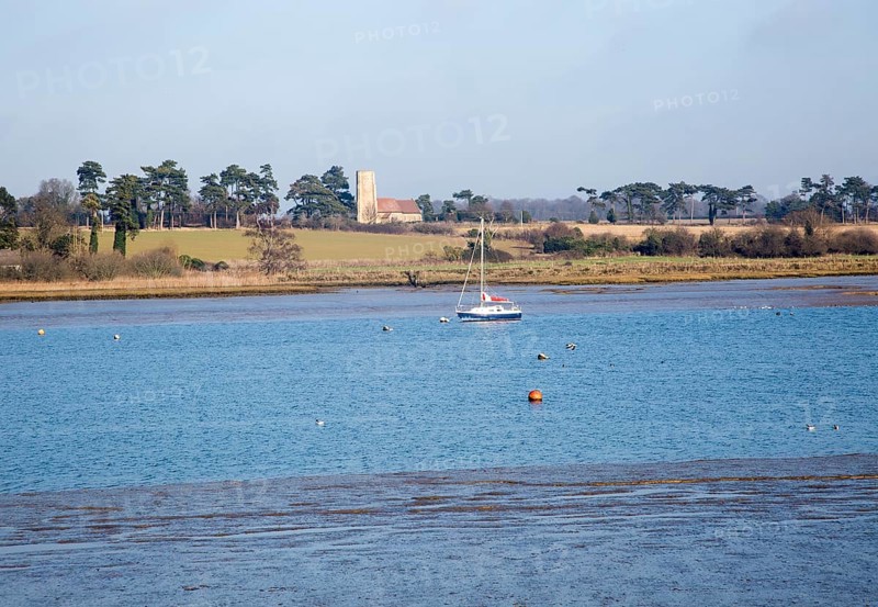 Ramsholt church and moored yacht seen from across River Deben, near Kirton Creek, Suffolk, England, UK