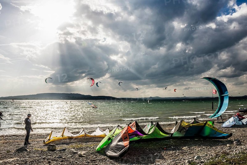 Kitesurfers and windsurfers in sun and storm, Reichenau Island, Untersee, Lake Constance, Baden-Württemberg, Germany, Europe