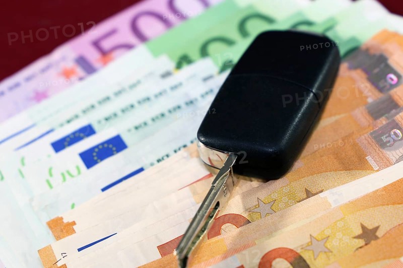 Euro banknotes and car keys as a symbol for car costs