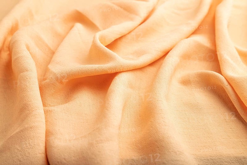 Fragment of orange linen tissue. Side view, natural textile background and texture. wave concept, abstract