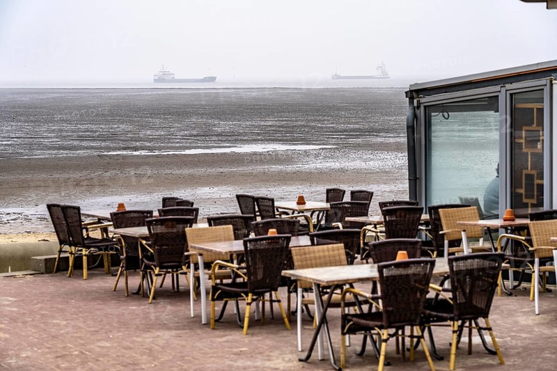 Thick fog in winter, hangs over the mouth of the Elbe into the North Sea, cafe on the dike, cargo ships, Cuxhaven, Lower Saxony, Germany, Europe