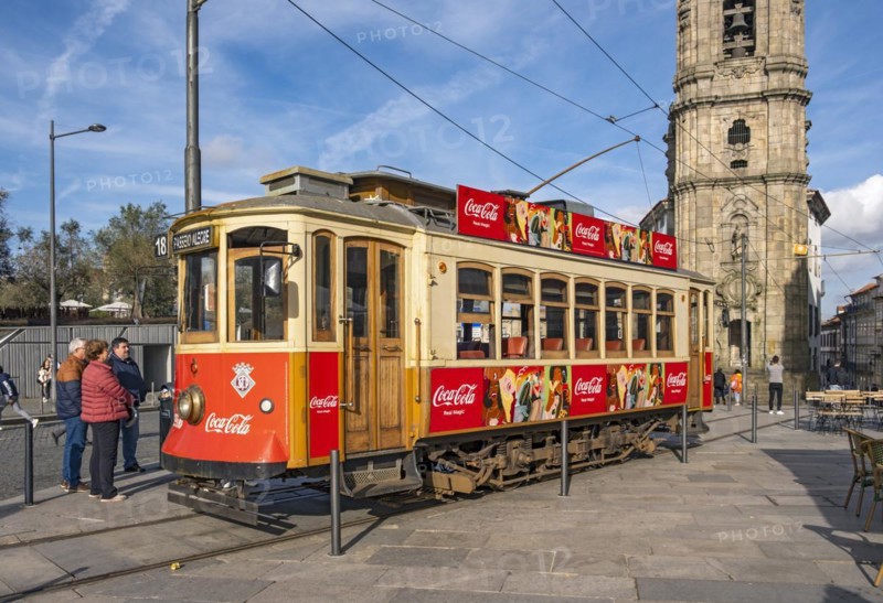 The iconic red tram number 18 pauses in front of the Clérigos Church Tower, Porto, Portugal, Europe