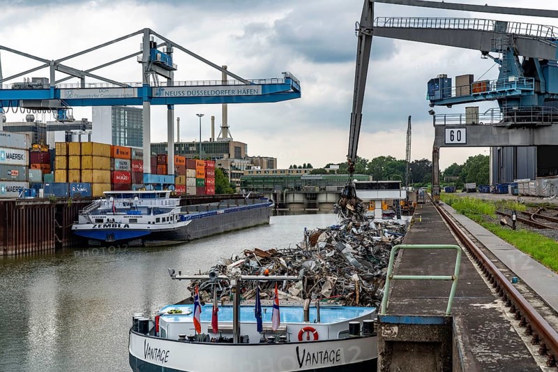 New customs yard building complex, the Gehry buildings, at the media harbour, behind it the city gate building, Neuss-Düsseldorf harbours, harbour facilities, cargo ship being loaded with scrap metal, quay of TSR Recycling GmbH & Co. KG, metal recycling, DCH Container Terminal, Düsseldorf, North Rhine-Westphalia, Germany, Europe