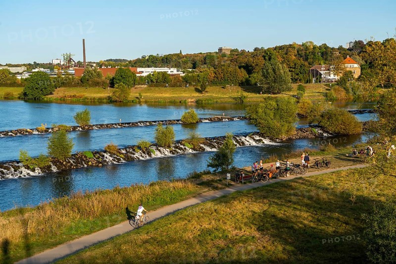 The Ruhr weir, barrage of the Ruhr near Hattingen, cyclist, on the Ruhr Valley cycle path, behind the LWL Industrial Museum Henrichshütte, North Rhine-Westphalia, Germany, Europe