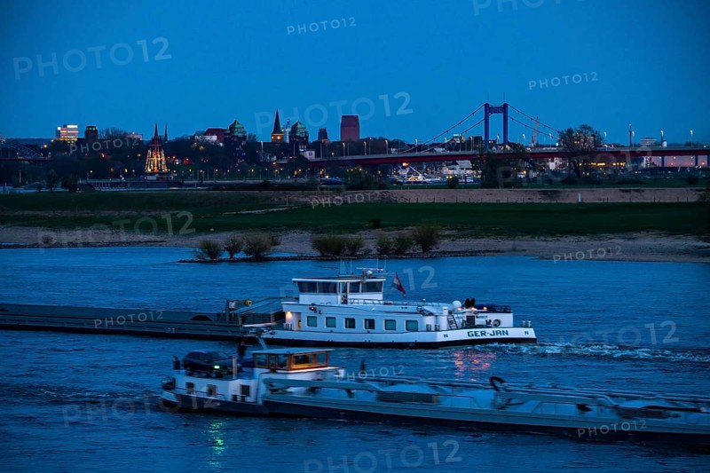 Cargo ship on the Rhine near Duisburg-Beeckerwerth, skyline of the city centre, with town hall, North Rhine-Westphalia State Archive Tower, Friedrich Ebert Bridge, Duisburg, North Rhine-Westphalia, Germany, Europe