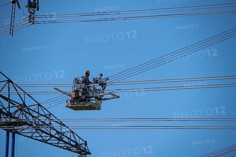 Construction of a new line route, 380 KV extra-high-voltage line between Osterath and Gohr, near Neuss, fitters in line trolleys, on the conductor cables, installing field spacers at great heights, North Rhine-Westphalia, Germany, Europe