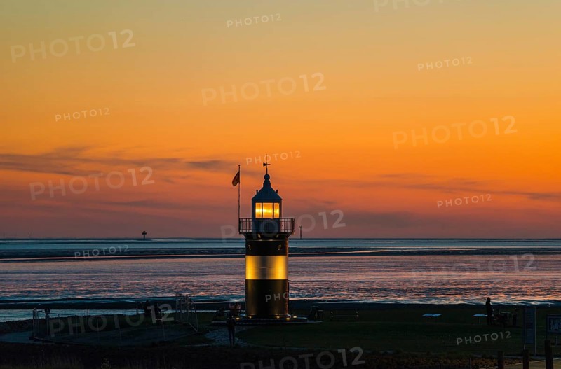 Black and white lighthouse, called 'Kleiner Preuße', stands on the coast in front of an orange-coloured sky shortly after sunset, twilight, evening, dusk, sea in the background, calm atmosphere, maritime, North Sea resort Wremen, Lower Saxony Wadden Sea National Park, World Heritage Site, Wurster North Sea coast, Land Wursten, district of Cuxhaven, Lower Saxony, Germany, Europe
