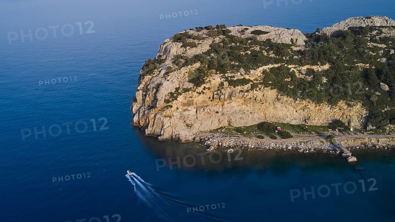 Drone shot, A rocky seashore with a small boat, calm water and a cloudless sky, Anthony Quinn Bay, Vagies Bay, Rhodes, Dodecanese, Greek Islands, Greece, Europe