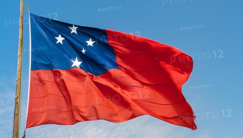 The flag of Samoa, fluttering in the wind, isolated against a blue sky