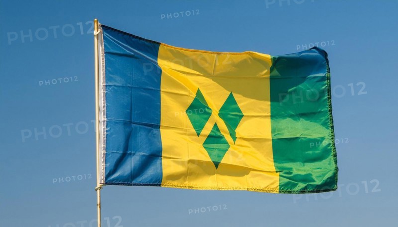 The flag of the Grenadines flutters in the wind, isolated against a blue sky