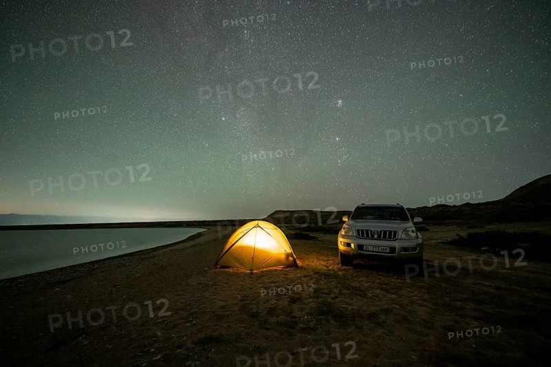 Off-road vehicle and tent, night shot, Milky Way at Lake Issyk Kul, Kyrgyzstan, Asia