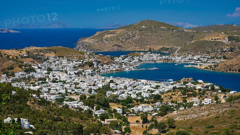 Picturesque coastal town with white houses and mountains in the background, surrounded by blue sea in Mediterranean climate, Skala, Patmos, Dodecanese, Greek Islands, Greece, Europe