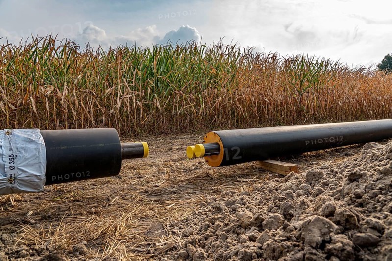 Laying of district heating pipes, next to a field, with maize, the district heating comes from a biogas plant and is fed directly into households in the neighbourhood, private provider, near Delbrück, North Rhine-Westphalia, Germany, Europe