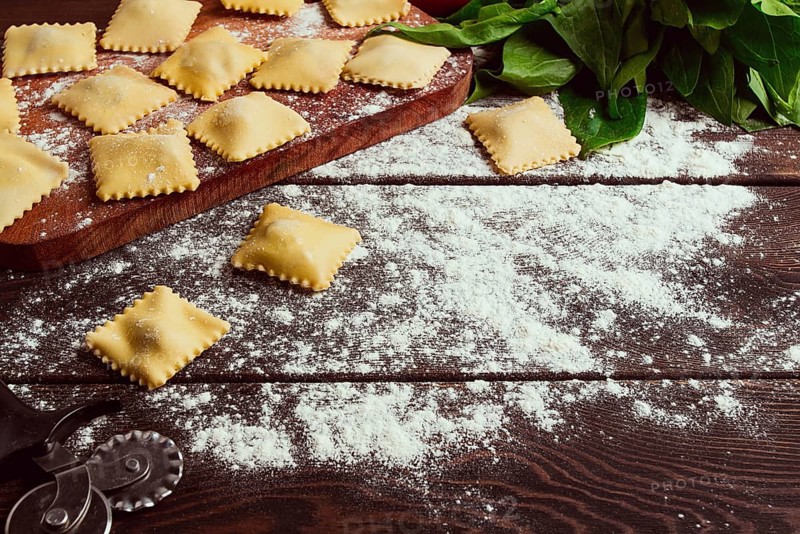 Cheese Ravioli, with spinach and cheese, with ingredients, on a wooden table, horizontal, no people, selective focus