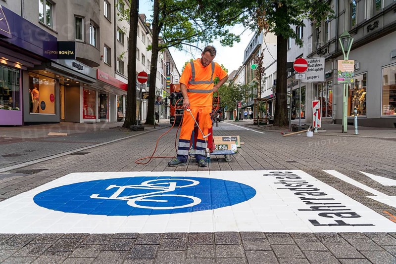 Application of road markings for a cycle lane, Rüttenscheider Straße in Essen, in the shopping and gastronomy district, cyclists have right of way over motorised vehicles, part of a cycle axis through Essen's city centre