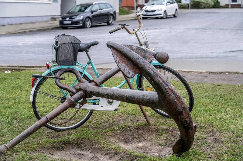 Bicycle, ladies' bicycle, well secured with a bicycle lock to an iron ship's anchor, in Bremerhaven, Bremen, Germany, Europe