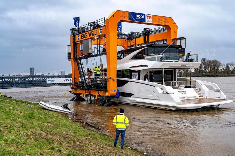 Craning the €6.3 million Sunseeker 88Y motor yacht, weighing 82 tonnes, in preparation for the world's largest water sports trade fair, Boot in Düsseldorf, luxury yachts are driven across the Rhine to the trade fair and brought ashore with the help of the Big Willi ship crane and transported to the exhibition halls on a low-loader, North Rhine-Westphalia, Germany, Europe