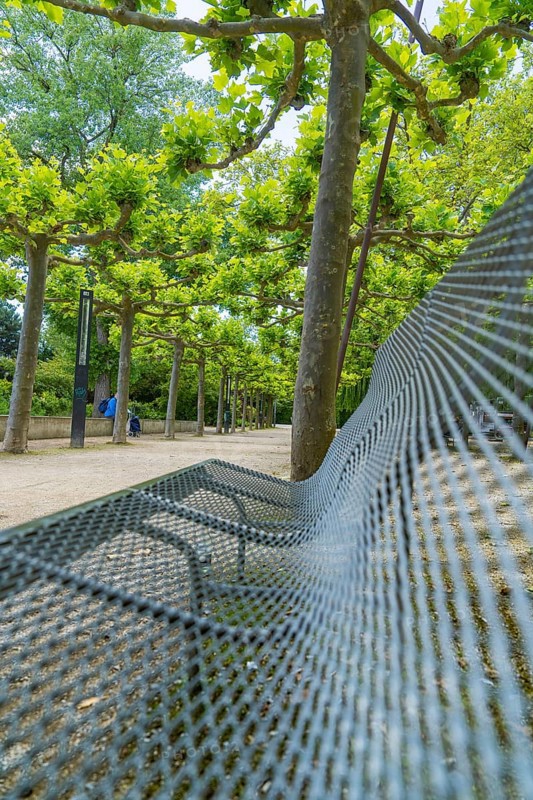 Corrugated metal bench under shady trees in an avenue, Böblingen, Germany, Europe