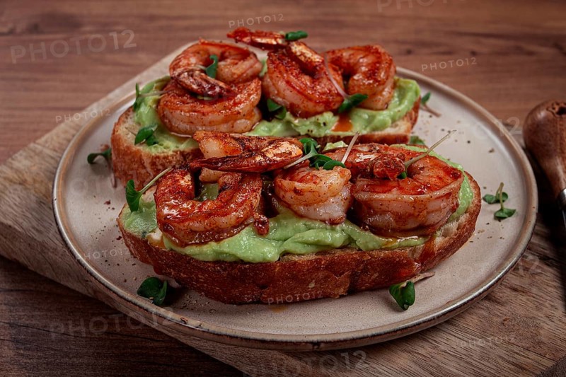 Sandwiches with avocado and caramelized shrimp, micro-greens, breakfast, on a plate, top view, homemade, no people
