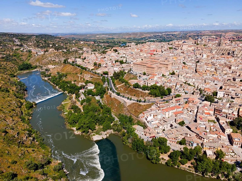 Aerial view of a city with many houses with a river flowing through it, with a bridge and hilly landscape, aerial view, Toledo, River Tagus, Castilla-La Mancha, Spain, Europe