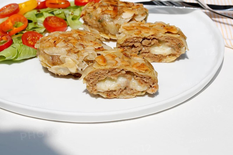 Swabian cuisine, meatballs wrapped in almonds, mixed minced meat, meatballs filled with cheese, fried, meatballs, grandmother's cooking, regional, home cooking, typical Swabian, traditional cuisine reinterpreted, served on a plate with salad, lettuce, cherry tomatoes, cocktail tomatoes, peppers, food photography, studio, Germany, Europe