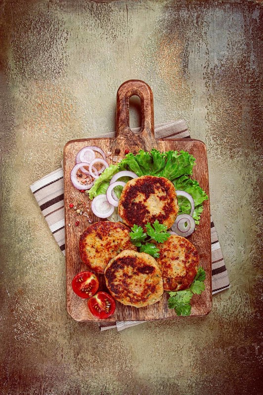 Fried chicken cutlets, minced chicken, with vegetables, on a cutting board, with vegetable salad, top view, homemade, no people