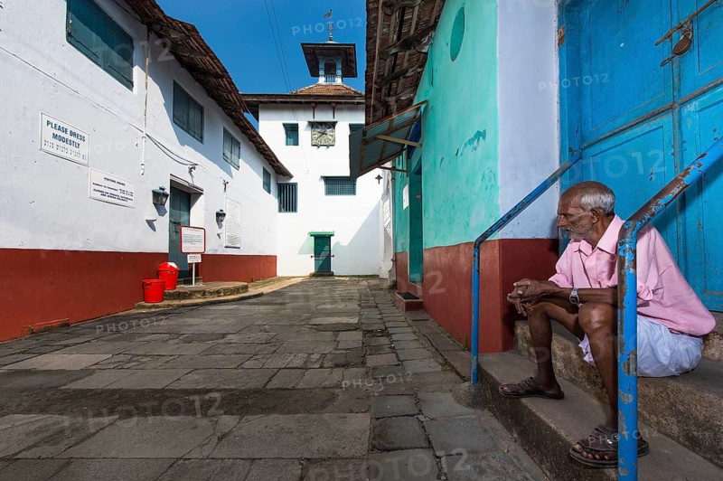 Man sitting on stairs near Paradesi Synagogue, Jewish Quarter or Jew Town, Mattancherry, Fort Cochin, Kochi, Kerala, South India, India, Asia
