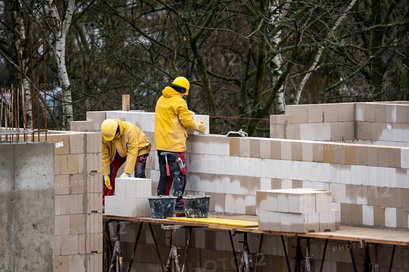 Building site, house being built, bricklayers at work, building a wall, on scaffolding, high