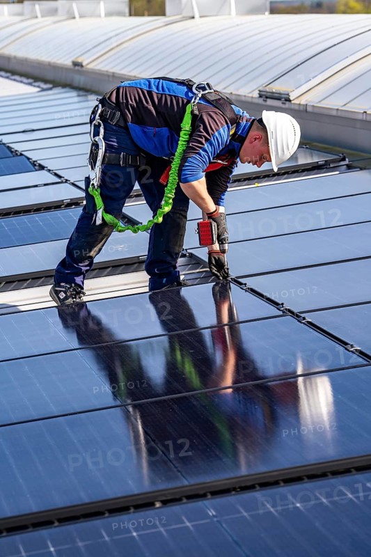 Installation of solar modules on the roof of a commercial enterprise, over 400 photovoltaic modules are installed on the roof, North Rhine-Westphalia, Germany, Europe