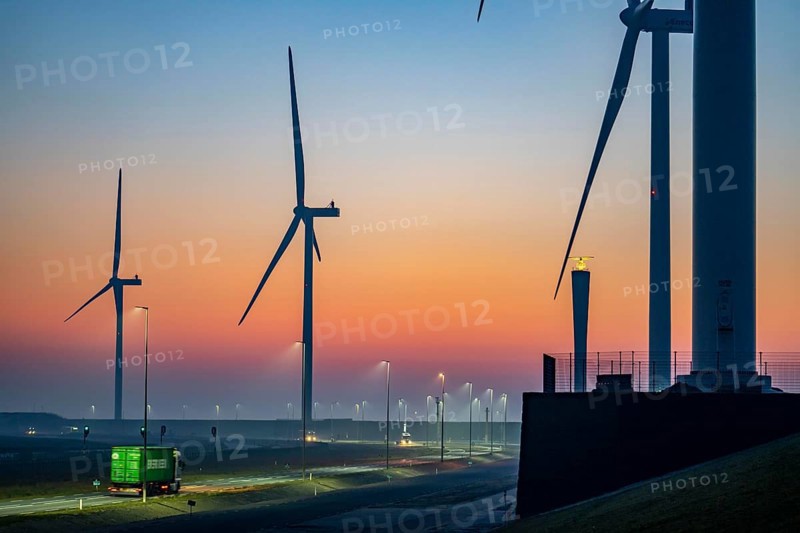 Lorry on the road from Euromax Terminal Rotterdam, ENECO wind farm on the dike around the port of Maasvlakte 2, 22 wind turbines with a capacity of 116 megawatts, sunset, Rotterdam, NetherlandsEvergreen Container