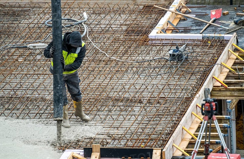 Construction site, concreting, the floor slab of a building is concreted, the concrete is pumped onto the reinforced concrete mats