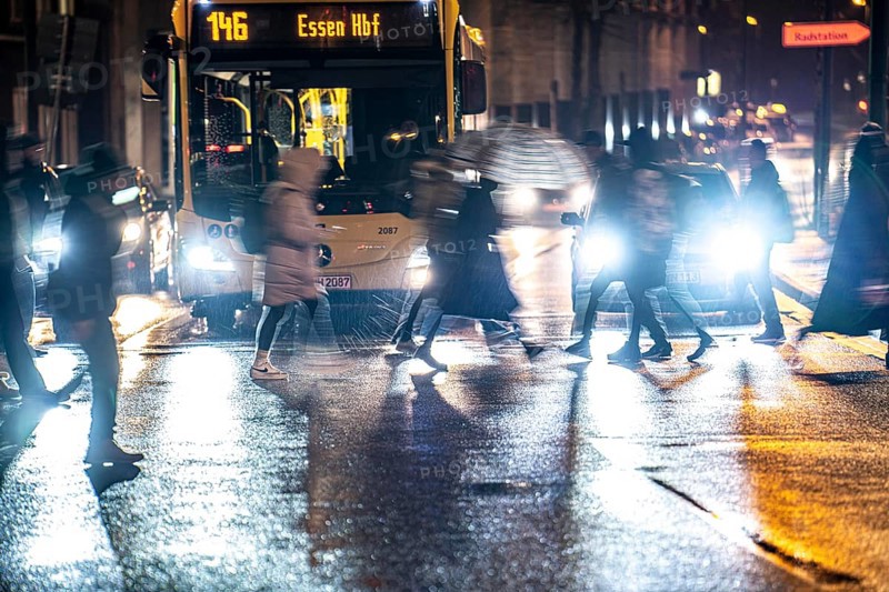 Passers-by at a pedestrian crossing, at the main railway station, rainy weather, city centre, in the evening, Essen, North Rhine-Westphalia, Germany, Europe
