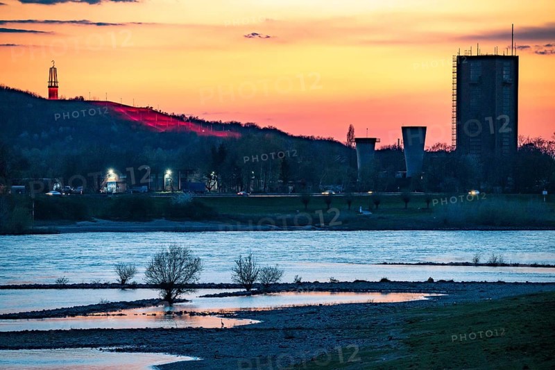 Cargo ship on the Rhine near Duisburg-Beeckerwerth, Rheinpreussen spoil tip in Mörs, spoil tip sign Das Geleucht, winding tower of the former Rheinpreußen Schacht VIII colliery, Duisburg, North Rhine-Westphalia, Germany, Europe