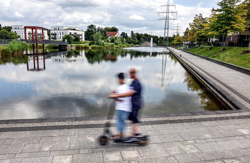 E Scooter rider at Niederfeldsee, Essen, 22.07.2024. The lake, built with funding from the state of North Rhine-Westphalia, is located on a former railway line, Essen, North Rhine-Westphalia, Germany, Europe