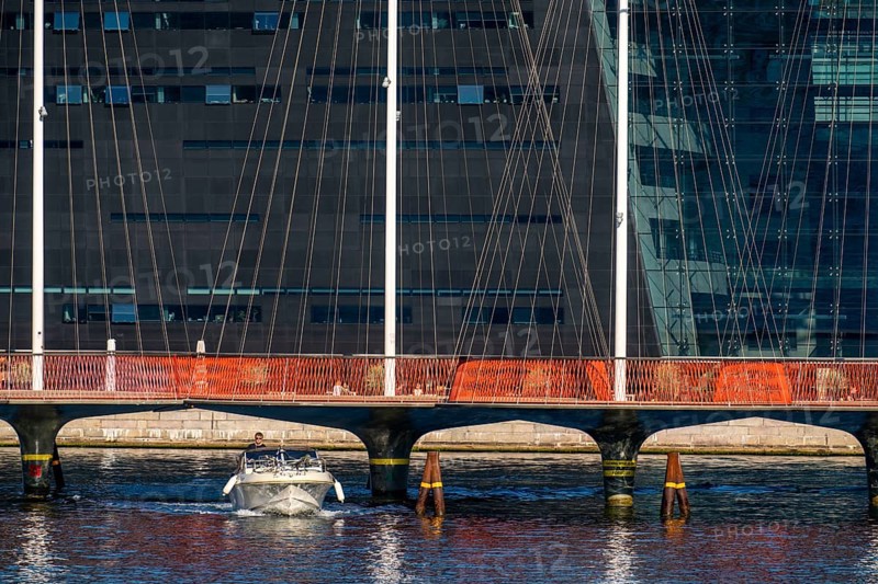 Cyclists on the Cirkelbroen cycle and footpath bridge, over the harbour, in the Christianshavens district, in the background the Danish Royal Library, Black Diamond, Copenhagen is considered the cycling capital of the world, 45 % of the population travel by bike, Denmark, Europe