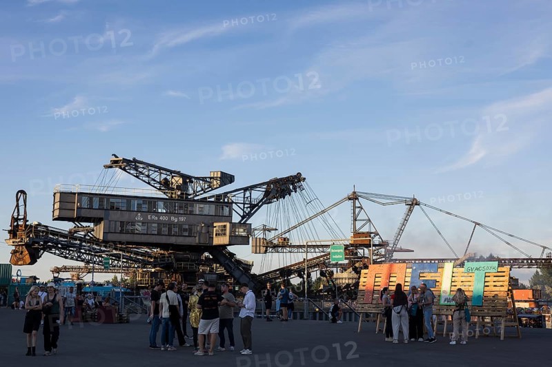 Festival visitors in front of open-cast mining excavator and Melt logo at the Melt Festival in Ferropolis on 13 July 2024. After a total of 27 years, the festival will take place for the last time in 2024