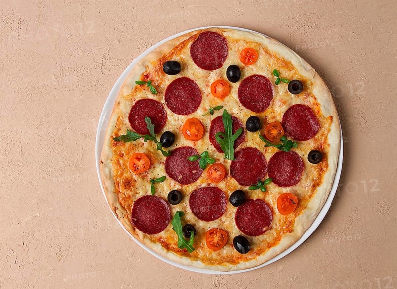 Pepperoni pizza, with olives and cherry, homemade, on a beige background, top view, no people